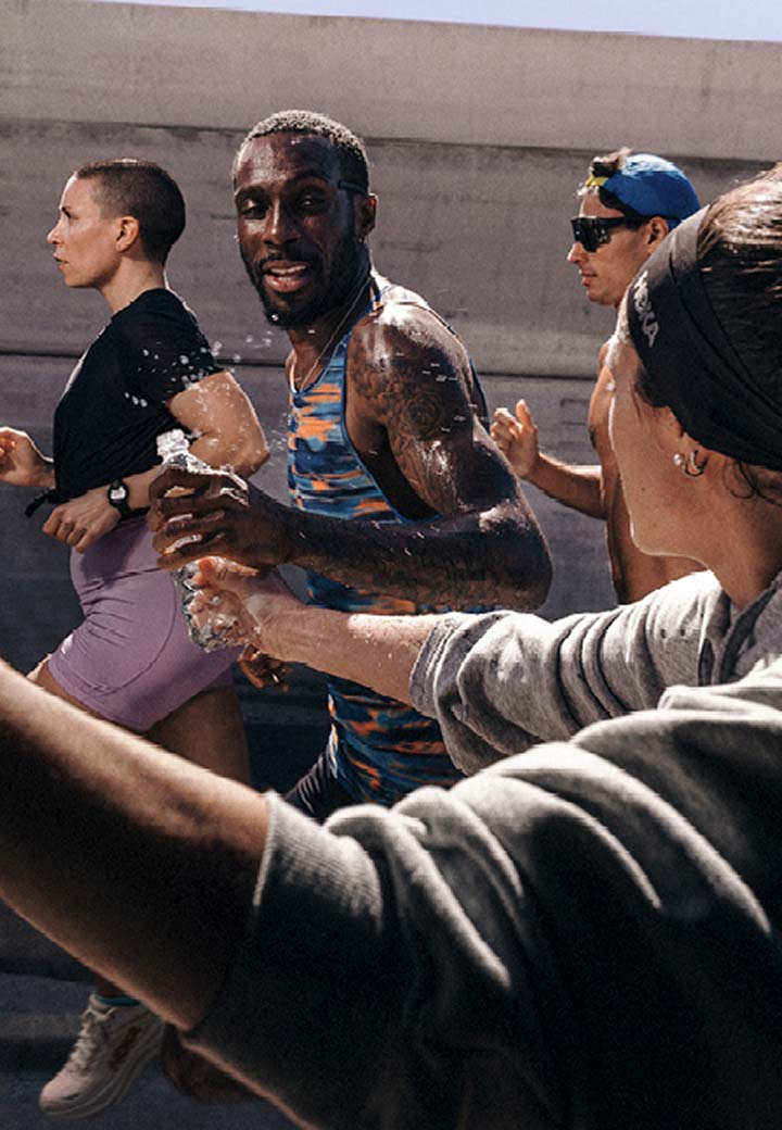 HOKA runners getting water from bystander on the road.